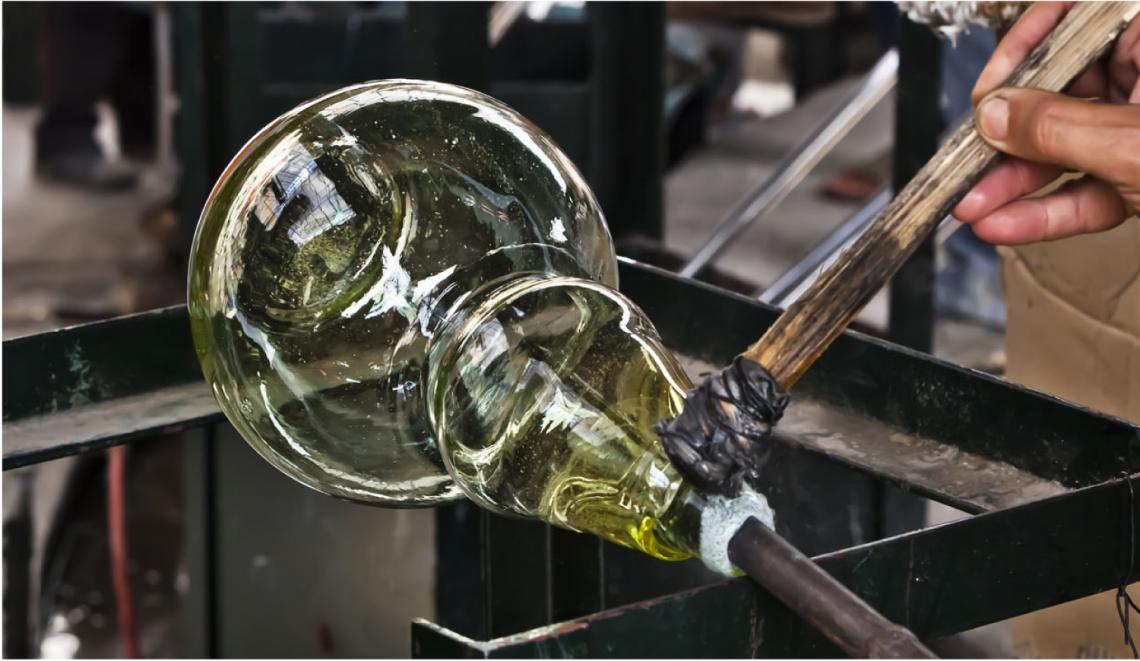 A glassblower gathering molten recycled glass in a Marrakech workshop